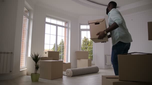 Alegre familia bailando llevando cajas a casa nueva — Vídeo de stock