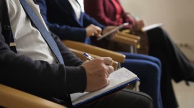 Eğitim sırasında dikkat çeken dinleyicilerin yakın çekim elleri