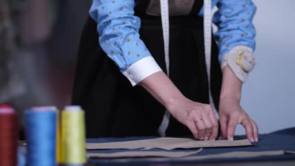 Руки портного, работающего с узорами на ткани — стоковое видео