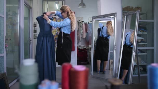 Schneiderin schneidert Ausschnitt aus Kleid auf Schaufensterpuppe — Stockvideo