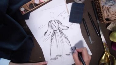 Moda krokisi üzerinde çalışan giysi tasarımcısı
