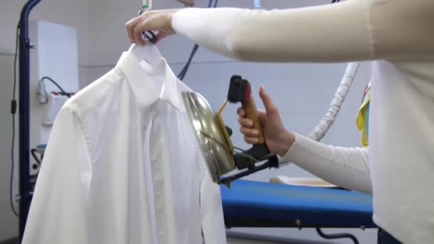 Steam ironing of white mans shirt in dry cleaning — Stock Video