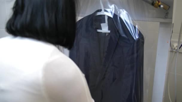 Workers hands putting packaging on cleaned suit — 비디오
