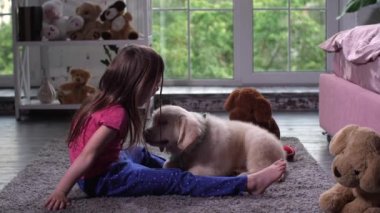 Küçük çocuk halı üzerinde köpek yavrusu evcil hayvan ile eğlenmek