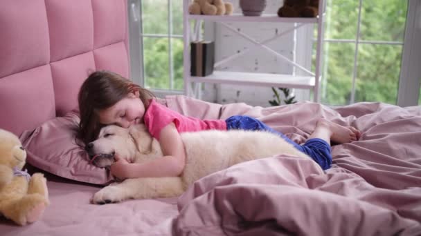 Linda niña despertando cachorro soñoliento en el dormitorio — Vídeo de stock