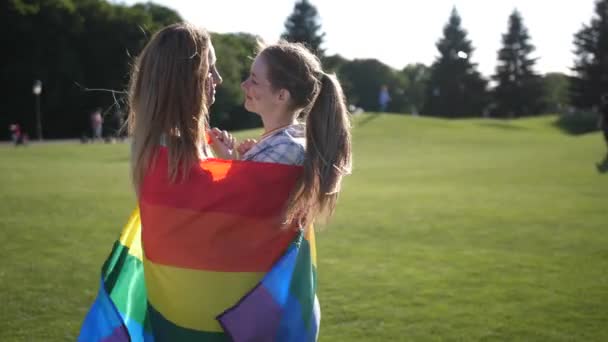 Молода гей-пара, що стоїть, загорнута в прапор lgbt — стокове відео