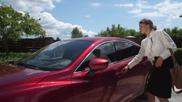 Женщина садится в машину, чтобы ехать на работу из дома — стоковое видео