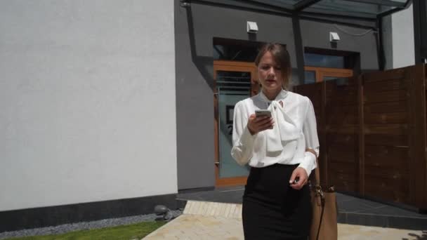 Занятая женщина с помощью смартфона, идущего к машине — стоковое видео