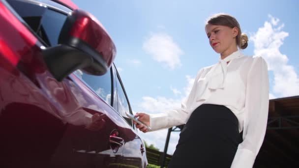 Affärskvinna låsa upp bilen med hjälp av smartphone app — Stockvideo