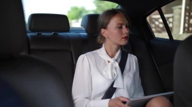 Ciddi kadın taksi ile işe gidiyor tablet kullanarak