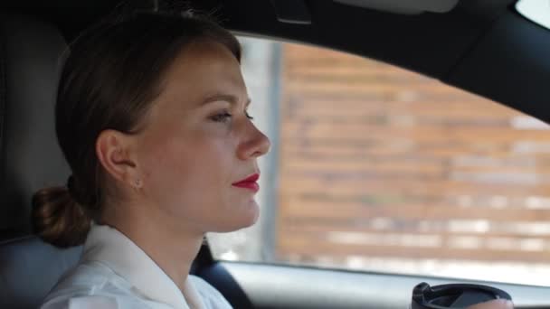 Retrato de mujer bebiendo café conduciendo coche — Vídeos de Stock