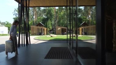 Otel girişine bavul taşıyan güzel kadın