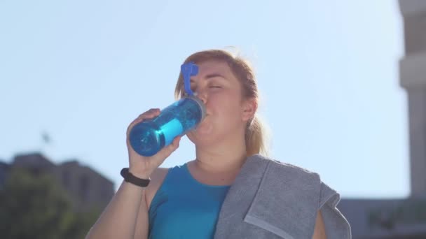 Portrait de femme fatiguée coureuse de graisse eau potable — Video