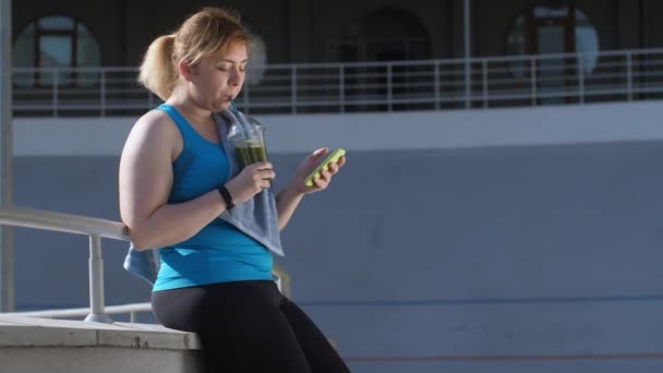 Nadwaga kobieta Jogger picie zielone smoothie — Wideo stockowe