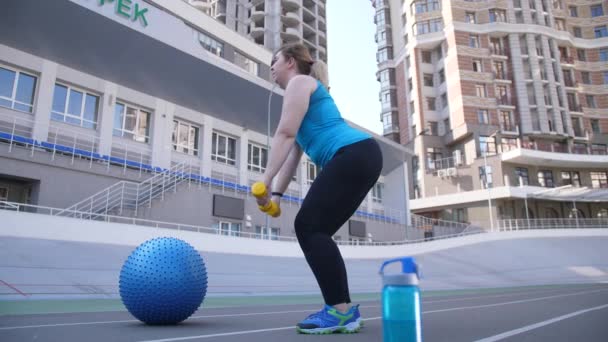 Плюс-размер женщины упражнения с гантелями на открытом воздухе — стоковое видео