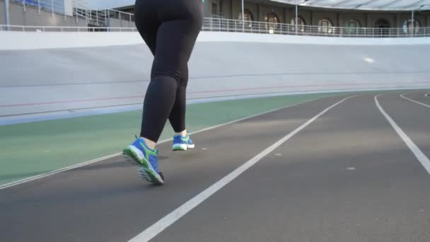 Beine übergewichtiger Joggerin auf Stadionstrecke — Stockvideo