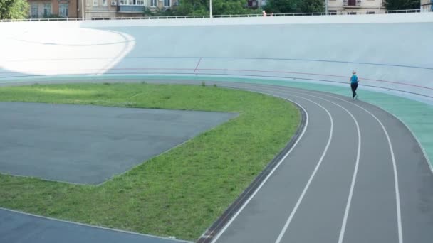 Drohnenschuss auf Läuferin beim Training auf Bahn — Stockvideo