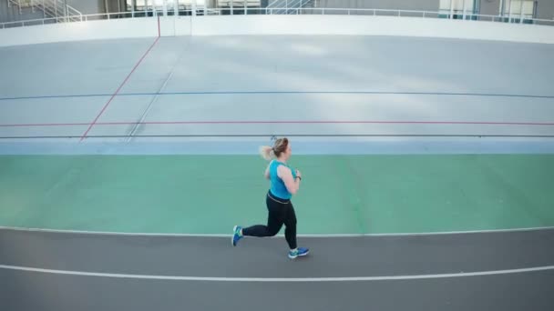 Drohnen-Blick auf übergewichtige Frau, die auf Gleis läuft — Stockvideo