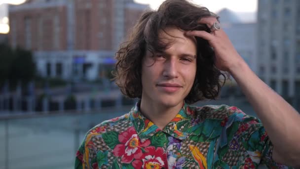 Portrait de jeune homme aux cheveux bouclés en plein air — Video
