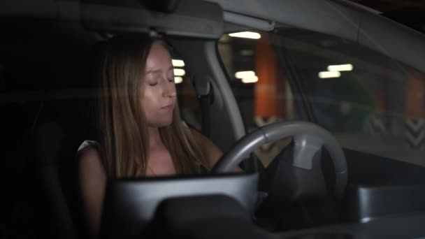Mooie vrouw krijgen in auto geparkeerd ondergronds — Stockvideo