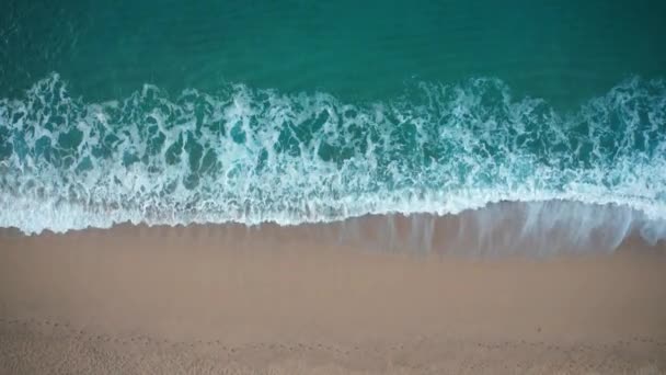 Vista superior das ondas azuis batendo contra a praia de areia — Vídeo de Stock