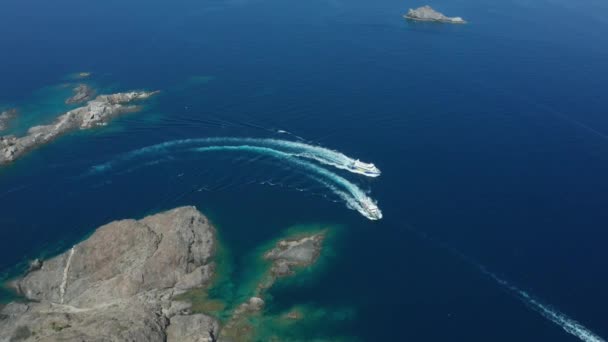 岩の岬の近くを航行する2つのヨットのドローンショット — ストック動画