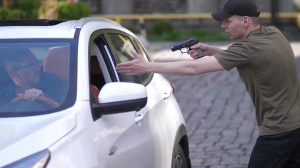 Ladrón loco fijando arma en el conductor sentado en el coche — Vídeos de Stock