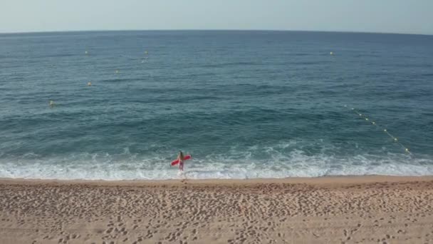 Blonde vrouw in bikini die in blauw zeewater loopt — Stockvideo
