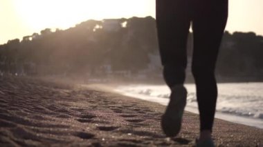 Aktif kadın gün doğumunda kumlu plajda koşu