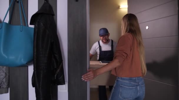 Kvinna som tar emot paket hemma från Delivery man — Stockvideo