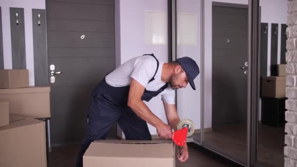 Worker packing removal boxes with adhesive tape — Stock Video