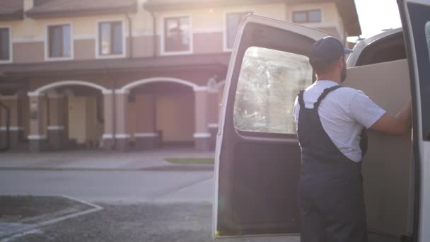 Delivery man nemen box uit van auto trunk — Stockvideo