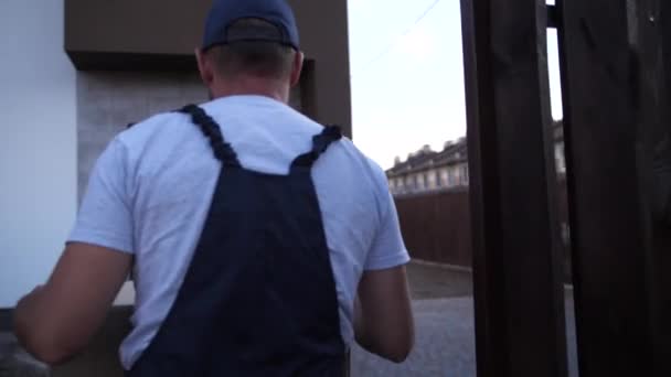 Delivery man leverera paket till dörr av hus — Stockvideo