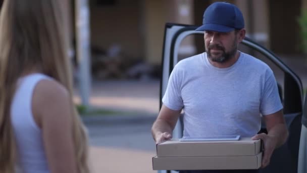 Чоловік з доставкою піци дає коробки для жіночого клієнта — стокове відео