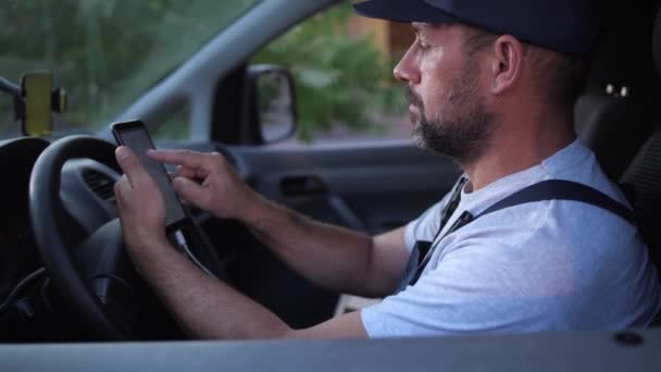 Bearded Delivery man välja rutt innan du kör — Stockvideo