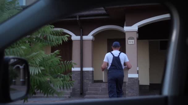 Entrega homem deixando pacote na porta da frente da casa — Vídeo de Stock