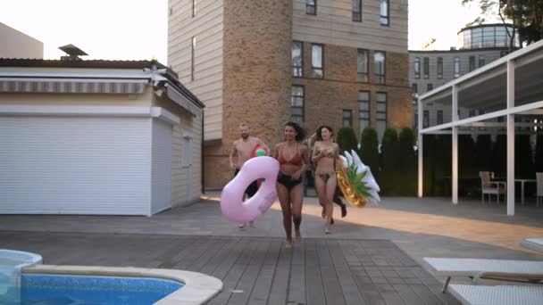 Havuza koşan mutlu çokuluslu gençler — Stok video