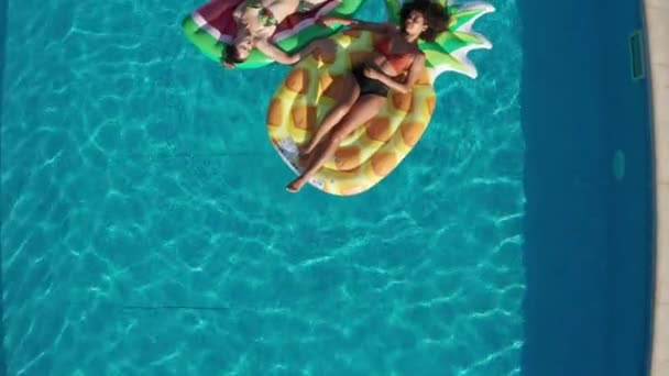 Drone shot di donne rilassate su galleggianti in piscina — Video Stock