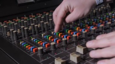 Karıştırma masası üzerinde çalışan müzik yapımcısının eli