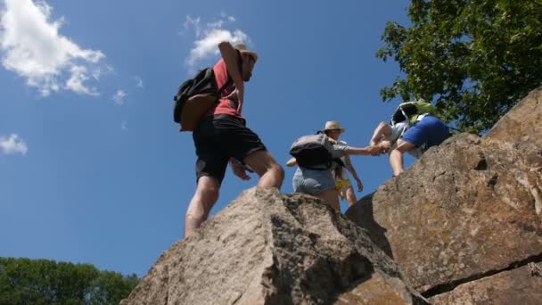 徒步旅行者帮助朋友爬上山顶 — 图库视频影像