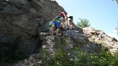 Sırt çantaları ile Yürüyüşçüler dik dağa tırmanma