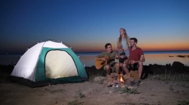 Arkadaşlar gece kamp ateşi yakın müzik keyfi