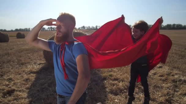 Homme courageux dans le jeu de rôle de super-héros avec son fils — Video