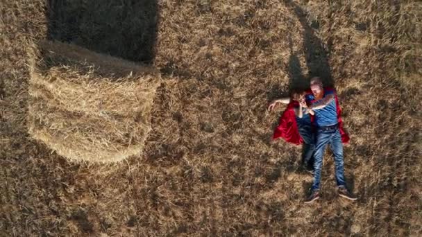 Vista dall'alto di papà e figlio supereroi sdraiati sul campo — Video Stock