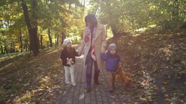 Szczęśliwa mama i małe dzieci spacerujące ścieżką parku — Wideo stockowe