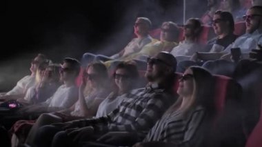 İzleyiciler 4dx sinema salonunda 3D film izliyor
