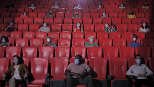 Multinationale Menschen in Masken lachen im Kino — Stockvideo