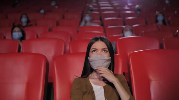 Портрет азиатки в маске в кинотеатре — стоковое видео