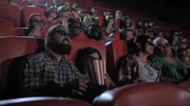 Karışık ırk ailesi sinemada 3D film izliyor.