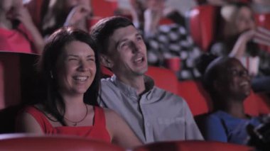 Neşeli çift sinemada komedi filminde eğleniyor.